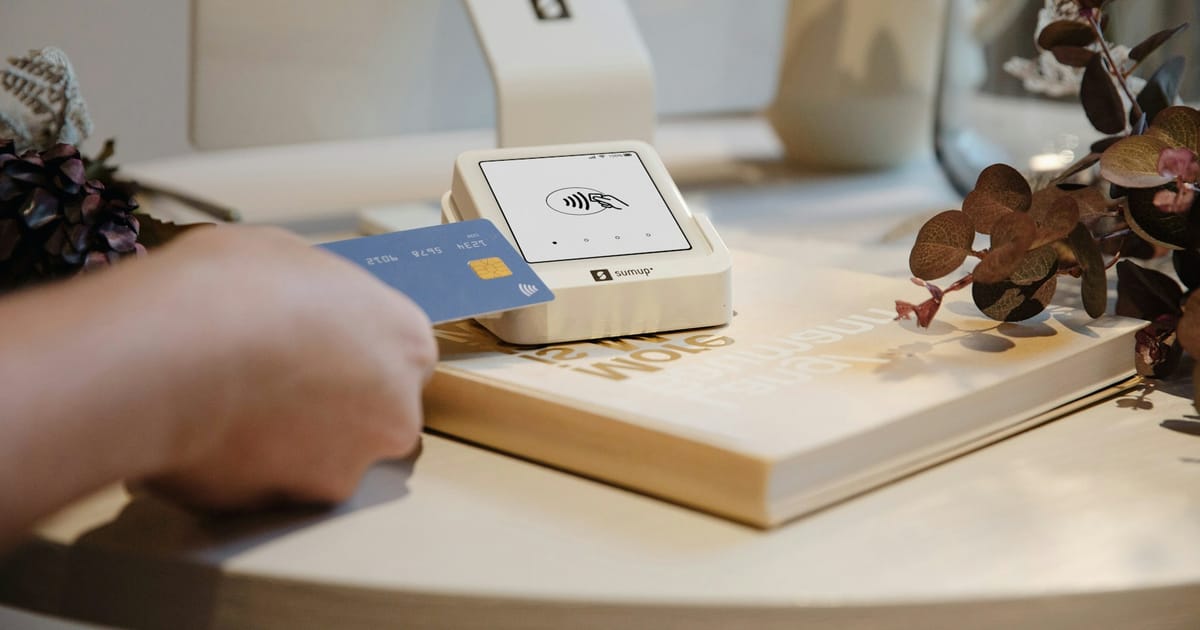 Una tarjeta se usa para pagar frente a un celular.