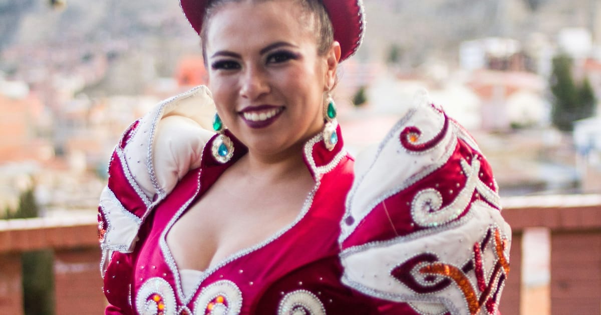 Una bailarina con traje rojo y blanco bordado y sombrero, durante una fiesta en La Paz.