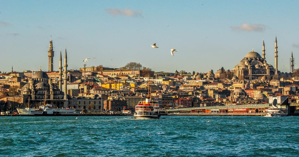 Un ferry cruza el Bósforo con la silueta de las mezquitas de Estambul al fondo.